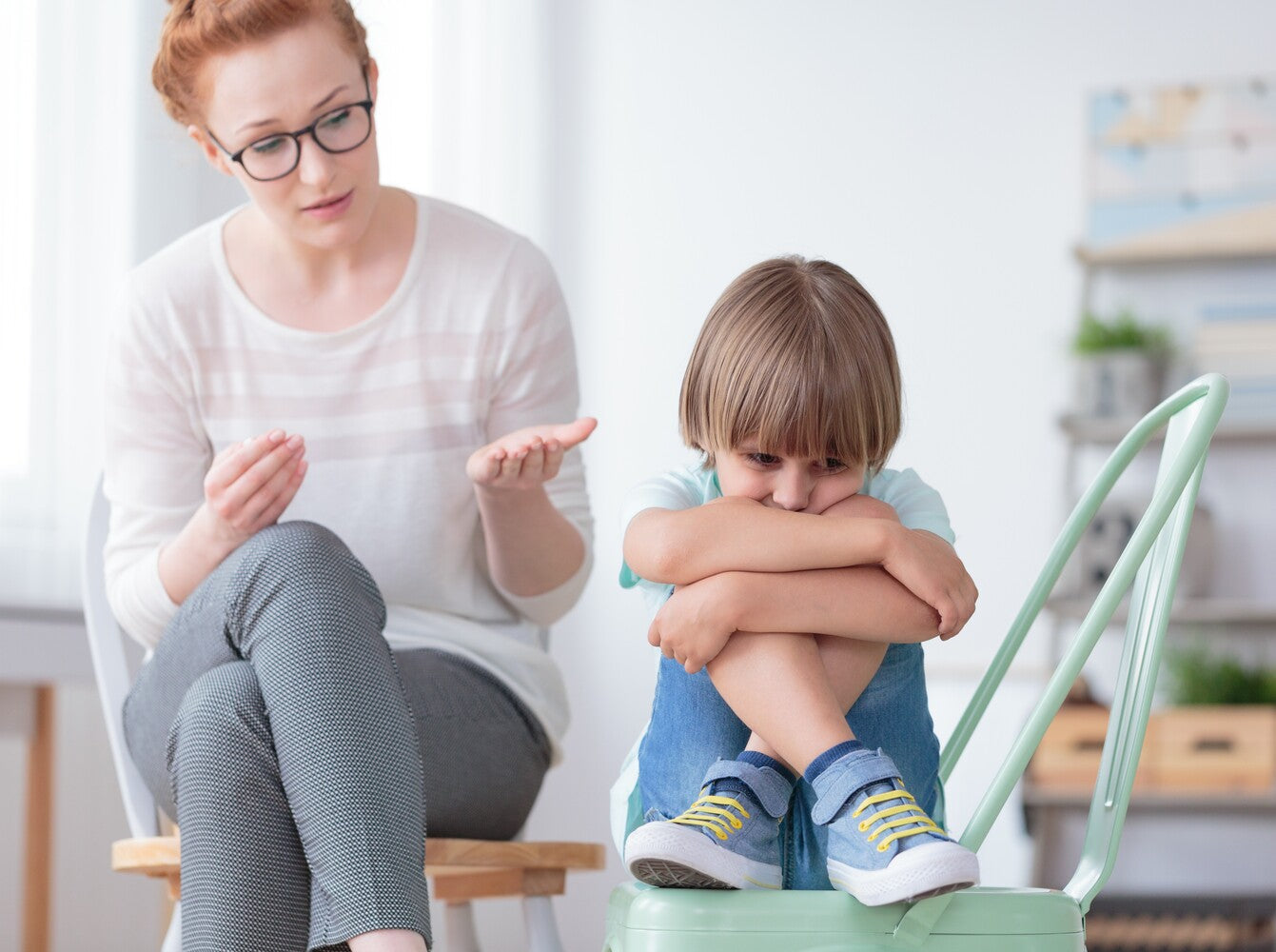 young boy struggling with his speech, showing why kids have speech impediments as he does a session with a speech therapist