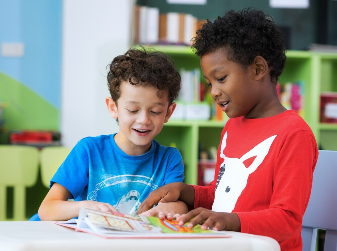 young boys reading together in a classroom, showing an early example of when do kids start reading by themselves