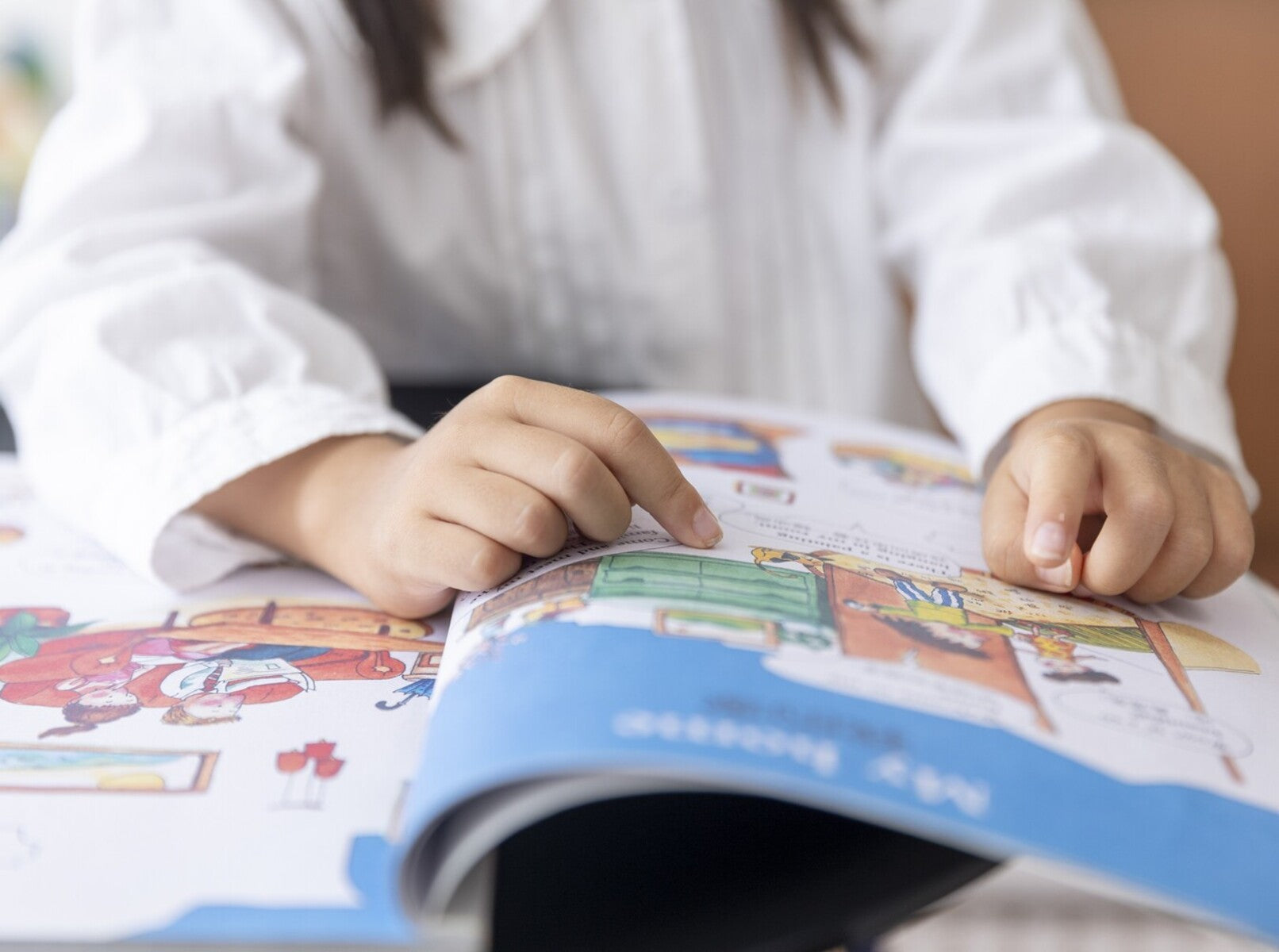young girl reading a fun book to work on her reading comprehension for kindergarten