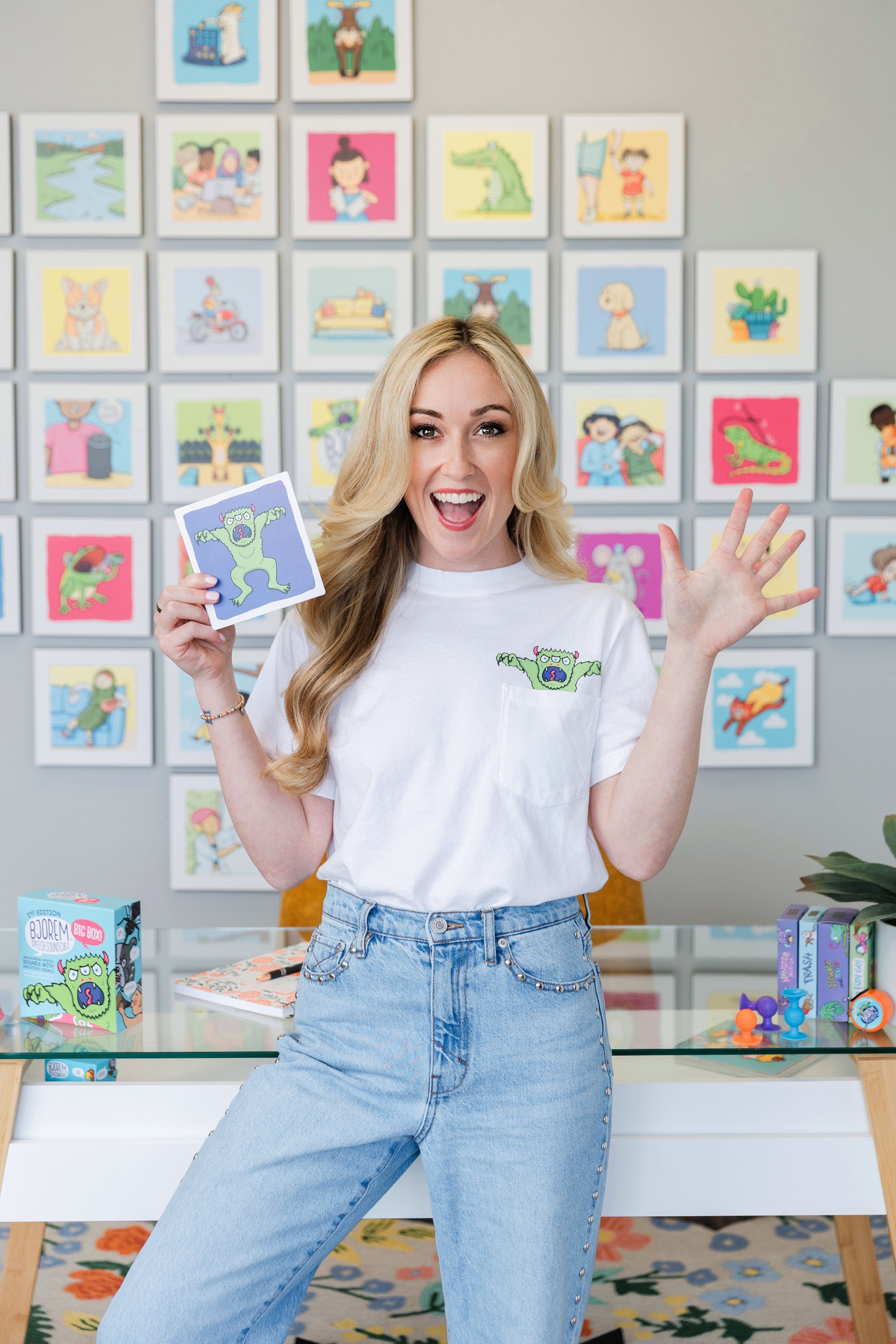 Woman holding artwork & wearing matching shirt.