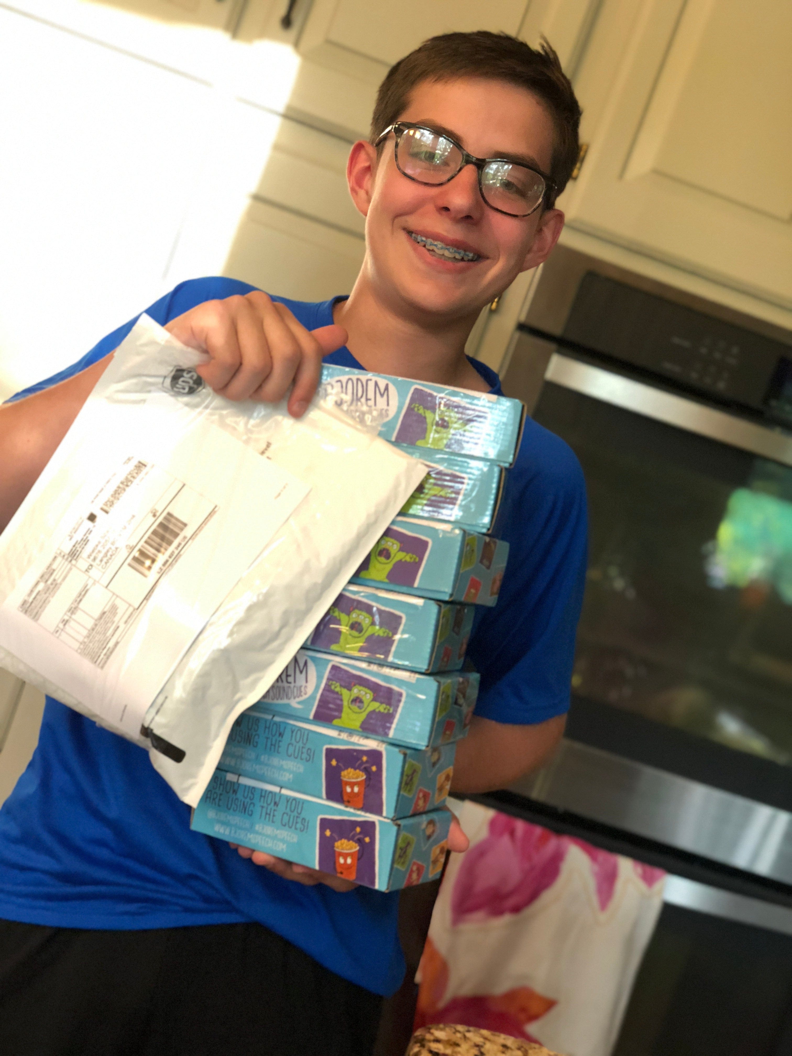 Teenager holding packages of board games.