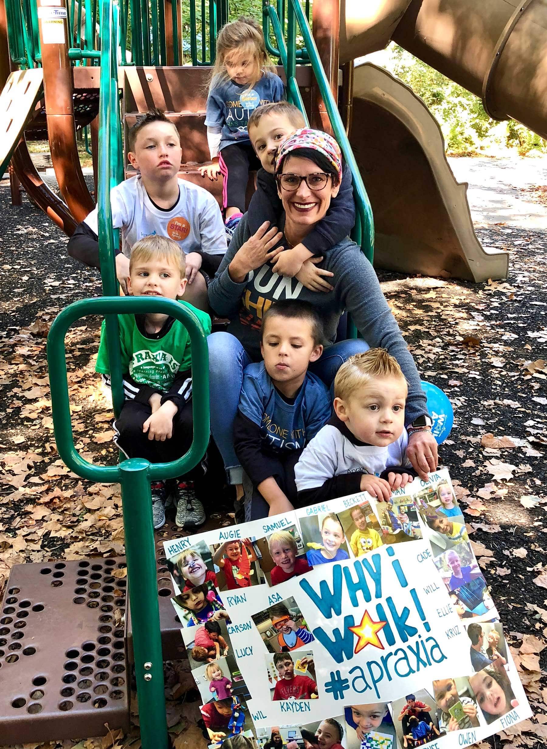 Group of children and adult on a playground slide.