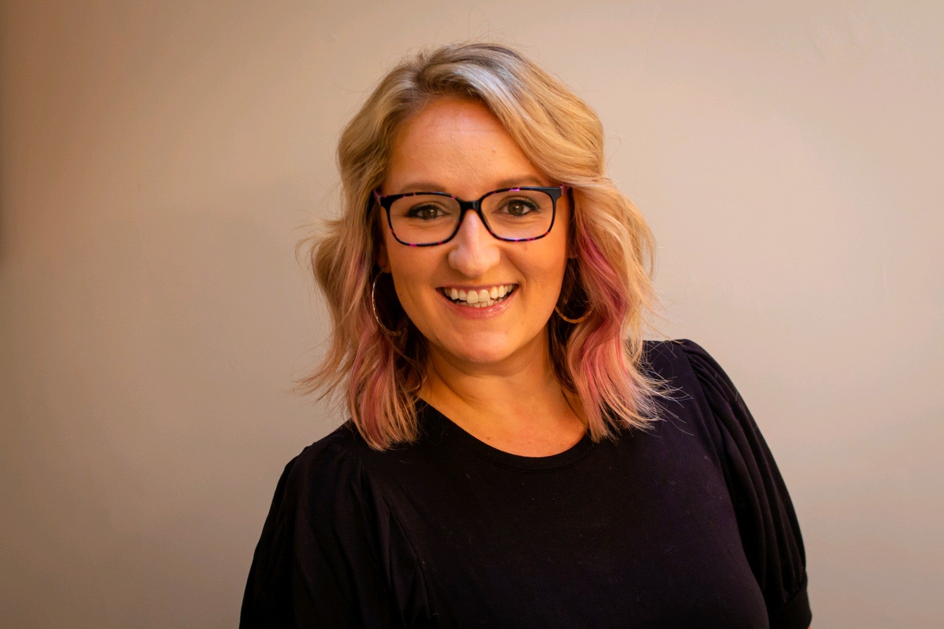Kelly Farquharson headshot, smiling with glasses