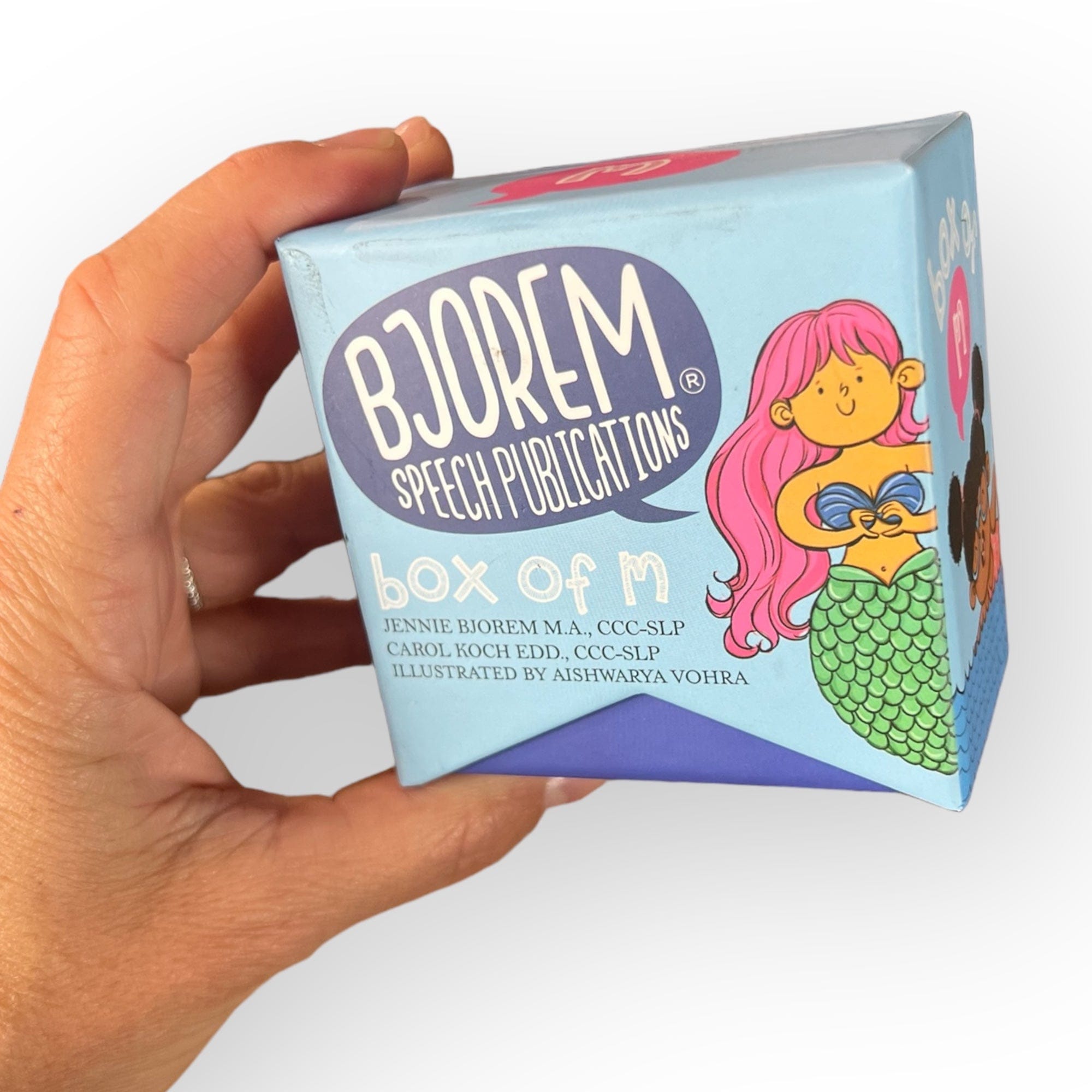 Box of M speech therapy cube held in hand, Photoroom image