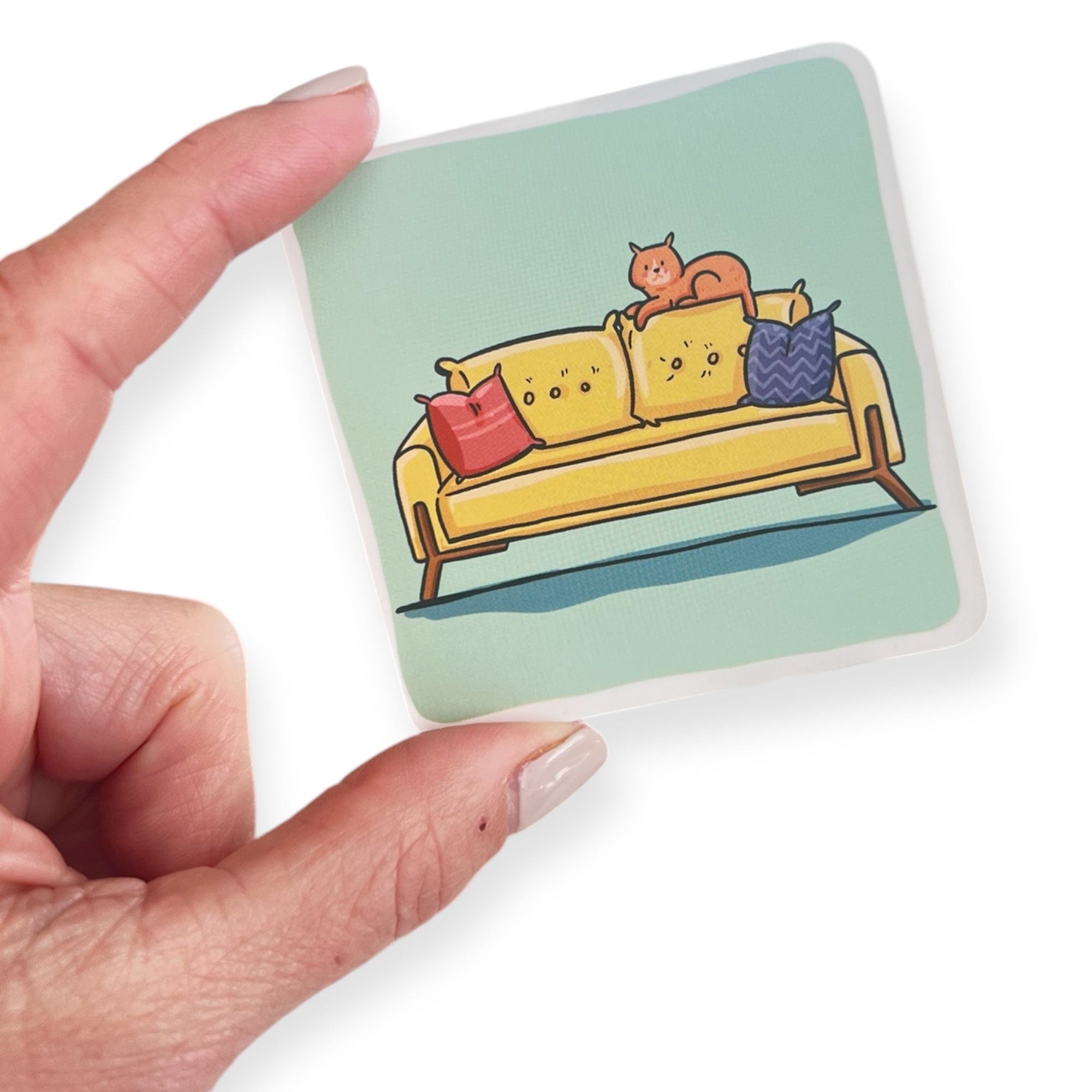 Cat on couch sticker held by hand - March 6, 2025