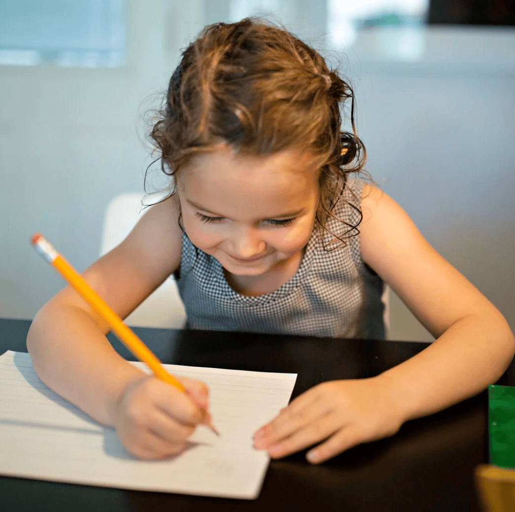 Girl writing at desk, screenshot from 2025-08-05 PM