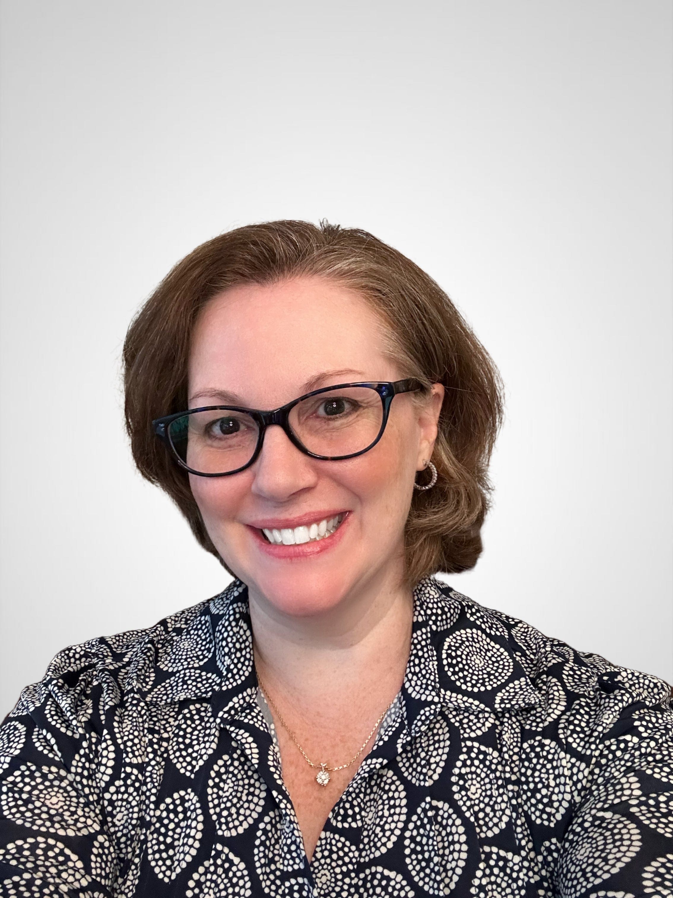 Joleen headshot smiling, wearing glasses