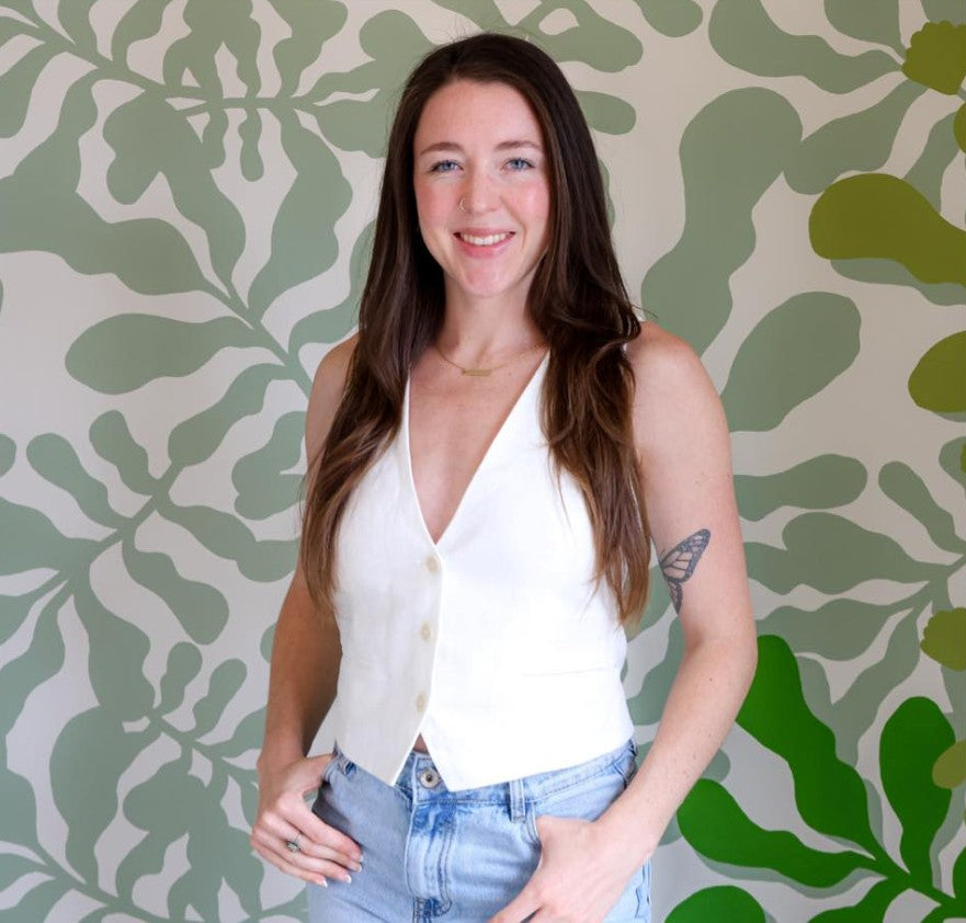 Ruthie Ozonoff smiling in front of a green patterned wall