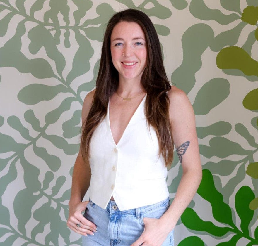 Ruthie Ozonoff smiling in front of a green patterned wall