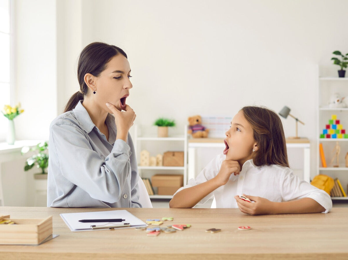best children’s speech therapist working with a young girl in a modern speech therapy office