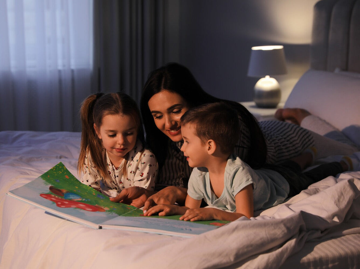 mother reading to her two children at home to get the benefits of reading to children