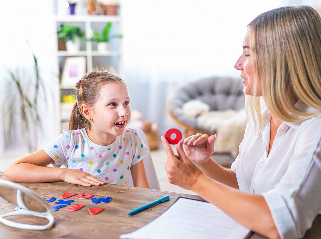 speech therapist helping a young girl with sounds, showing what apraxia is in kids