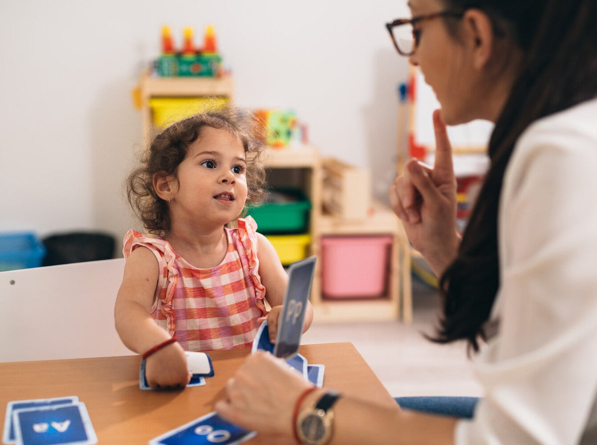 speech therapist using cards and gestures for childhood apraxia of speech treatment ideas with a young girl