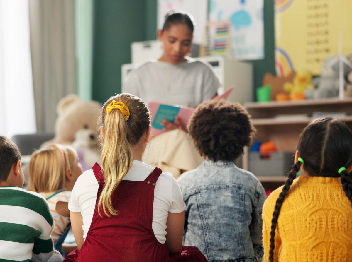 teacher reading a story to her class because she understands the importance of reading to children