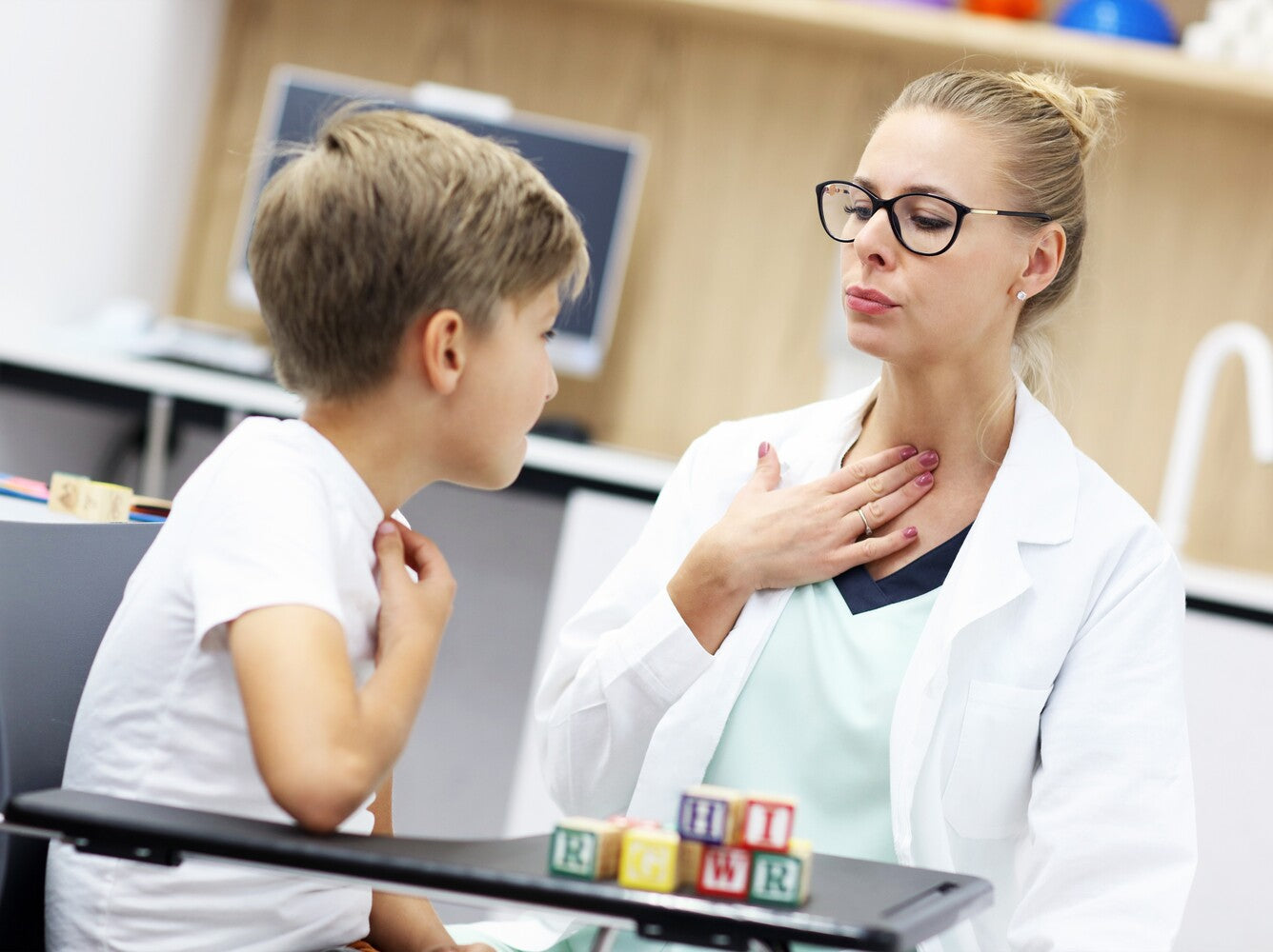 young boy doing a session with an SLP after experiencing signs your child needs speech therapy