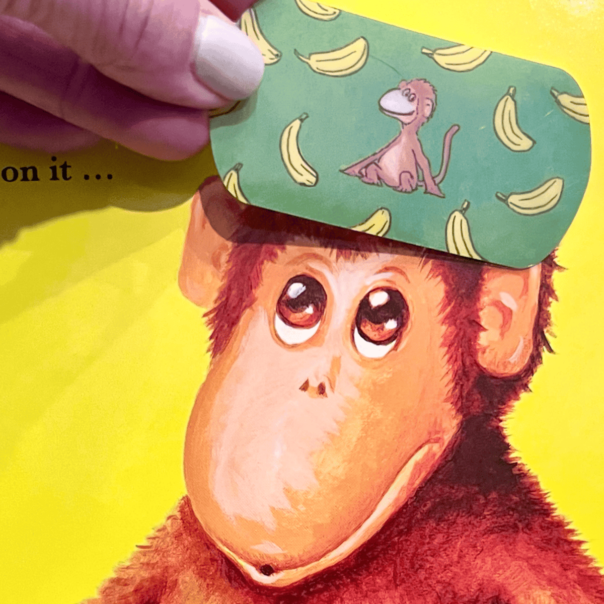 Inside page of the All Better board book with a reusable bandage sticker on a monkey