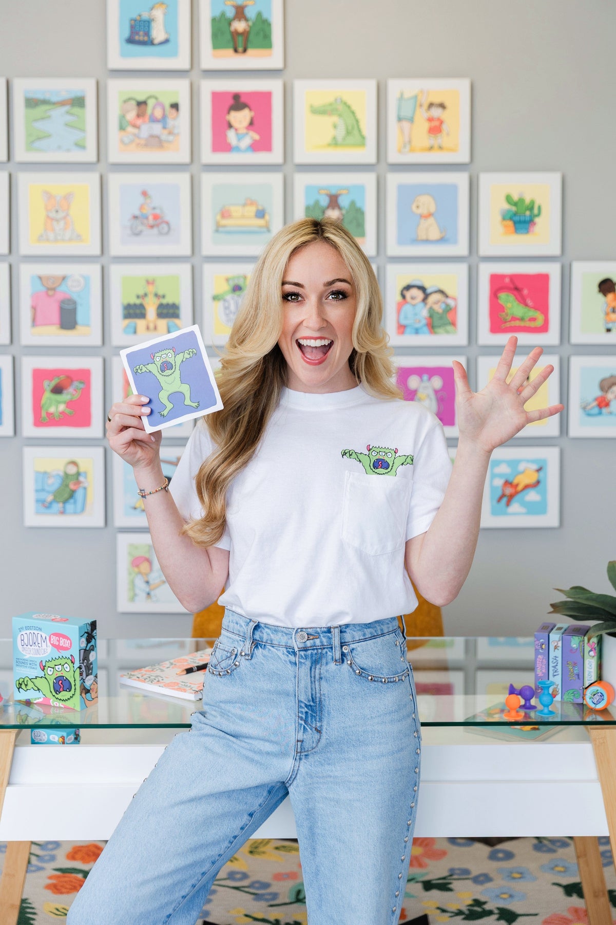 Woman holding artwork & wearing matching shirt.