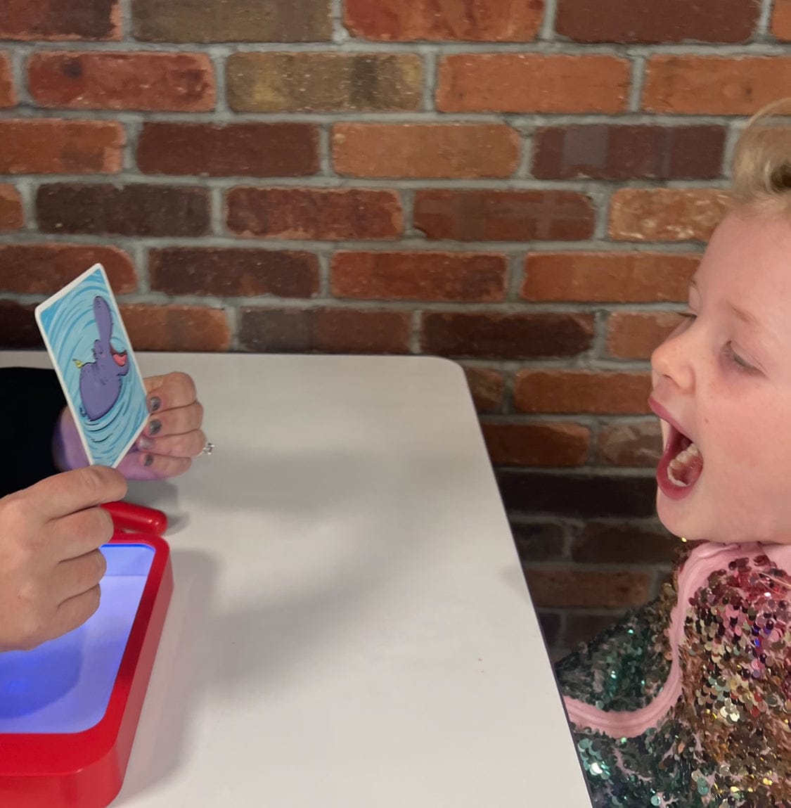 Child using the Oral Motor Assessment cards